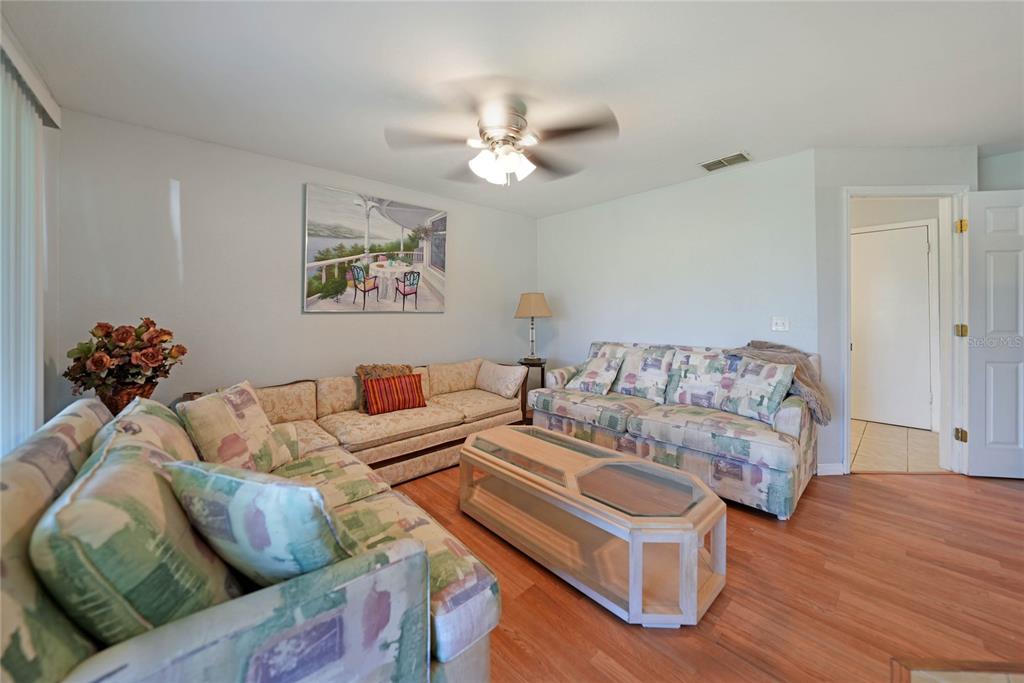 590 Ridgewood Street Northwest Port Charlotte, FL 33952 - Photo 13 of 32 a living room with furniture and a chandelier