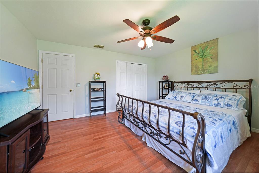 590 Ridgewood Street Northwest Port Charlotte, FL 33952 - Photo 14 of 32 a bedroom with a bed and a chandelier