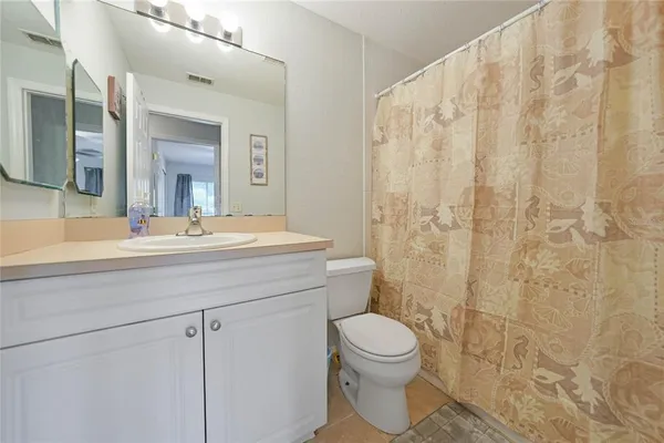 a bathroom with a toilet a sink a shower and a mirror