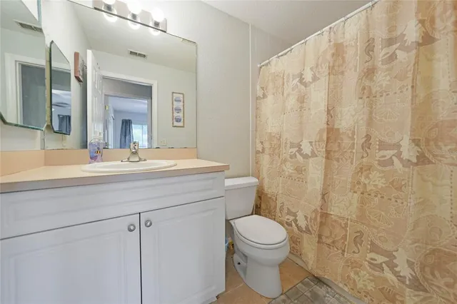 a bathroom with a toilet a sink a shower and a mirror