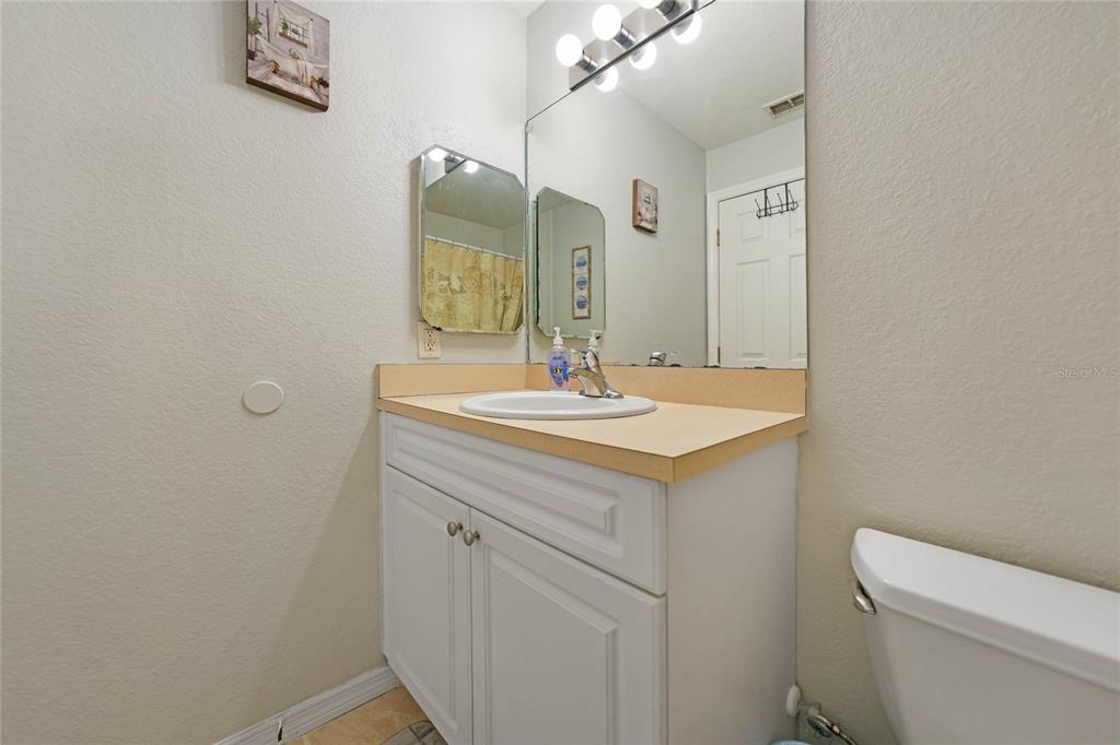590 Ridgewood Street Northwest Port Charlotte, FL 33952 - Photo 23 of 32 a bathroom with a sink a toilet and mirror