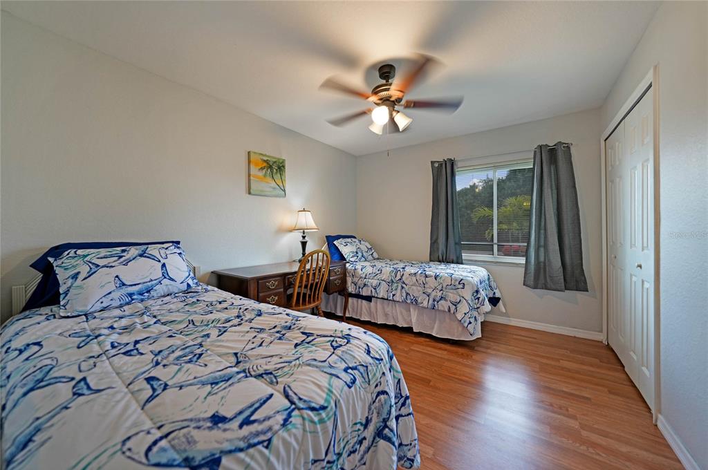 590 Ridgewood Street Northwest Port Charlotte, FL 33952 - Photo 24 of 32 a bedroom with two beds and a chandelier