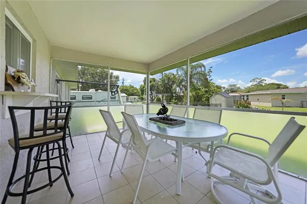 a dining room with furniture and a floor to ceiling window