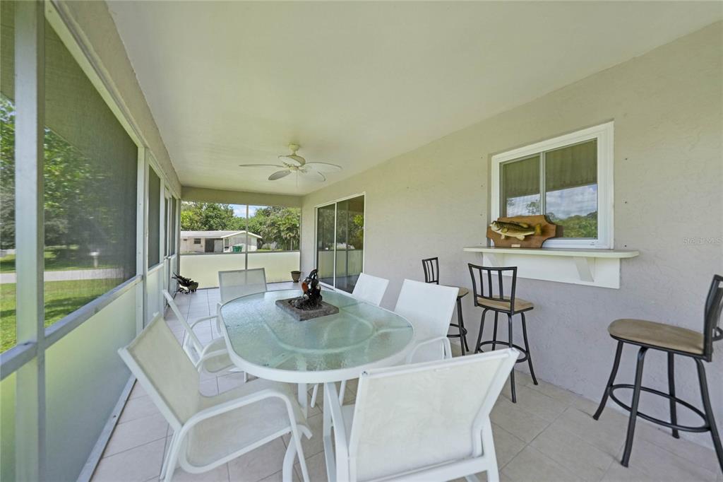 590 Ridgewood Street Northwest Port Charlotte, FL 33952 - Photo 29 of 32 a dining room with furniture and a floor to ceiling window