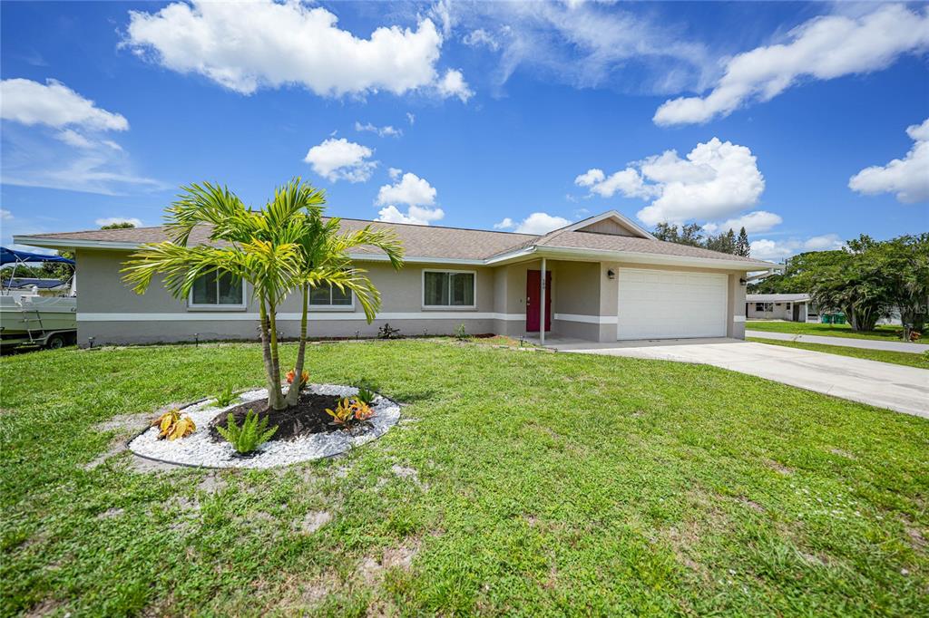 590 Ridgewood Street Northwest Port Charlotte, FL 33952 - Photo 3 of 32 a front view of a house with garden
