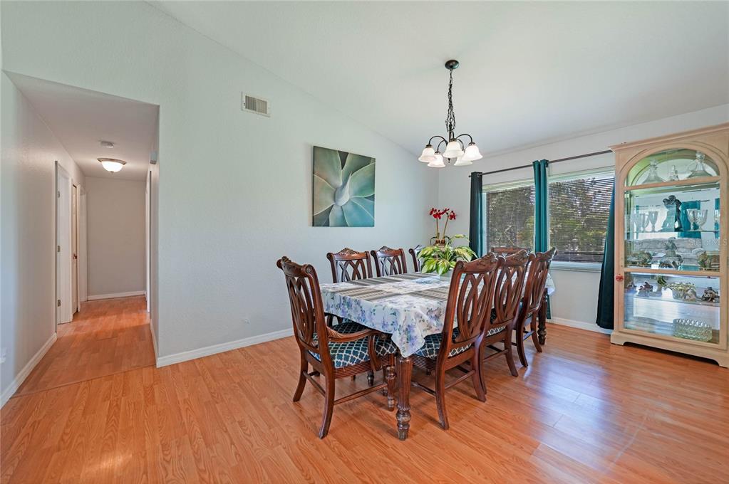 590 Ridgewood Street Northwest Port Charlotte, FL 33952 - Photo 6 of 32 a view of a dining room with furniture window and wooden floor