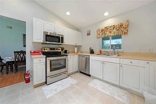 a kitchen with white cabinets stainless steel appliances and sink