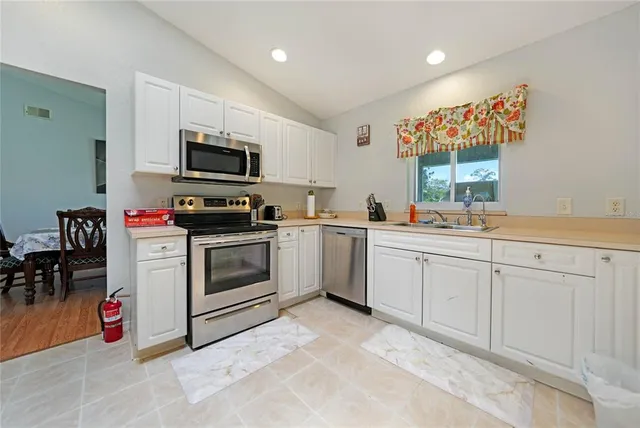 a kitchen with white cabinets stainless steel appliances and sink