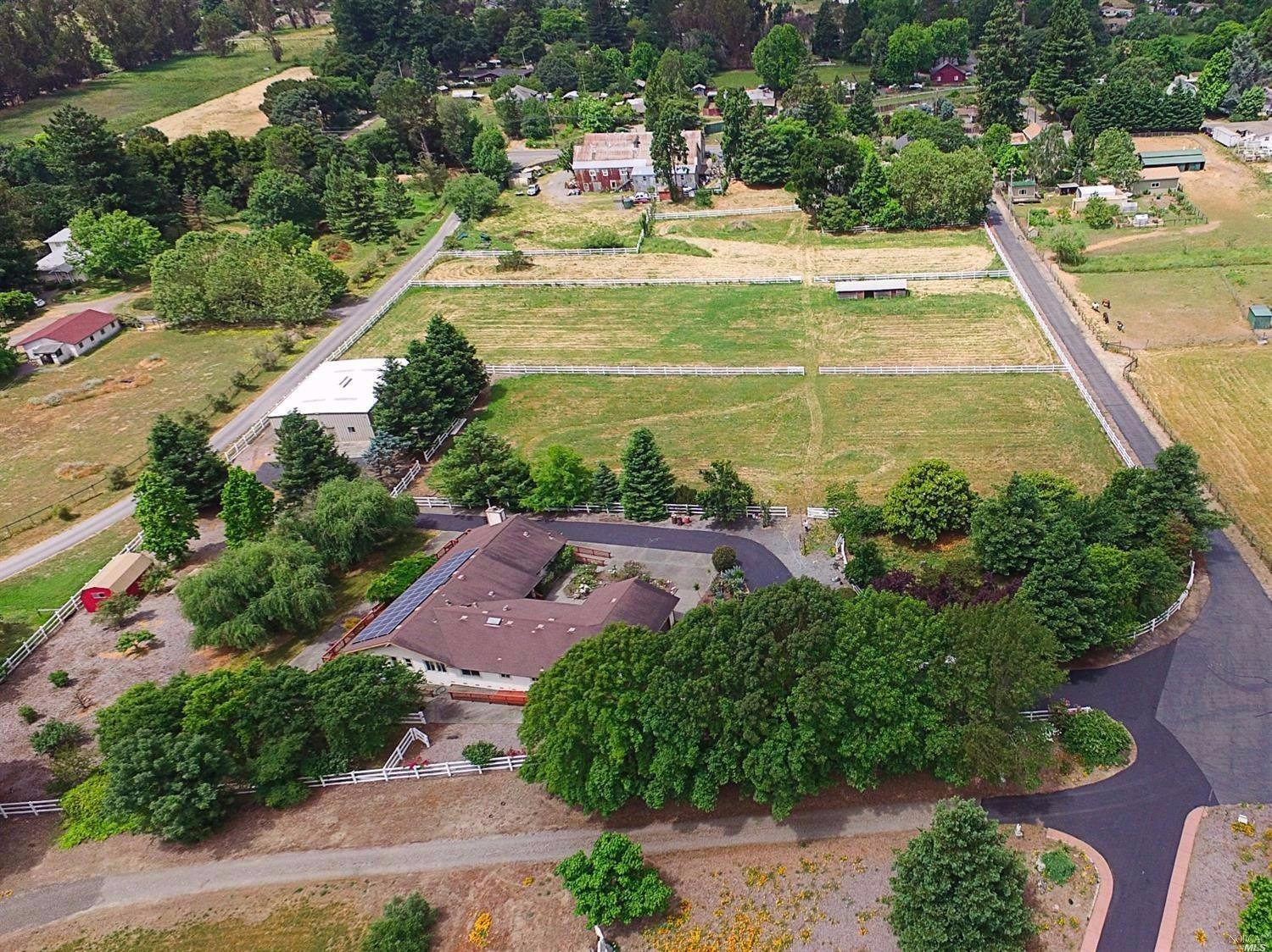 an aerial view of residential houses with outdoor space and lake view