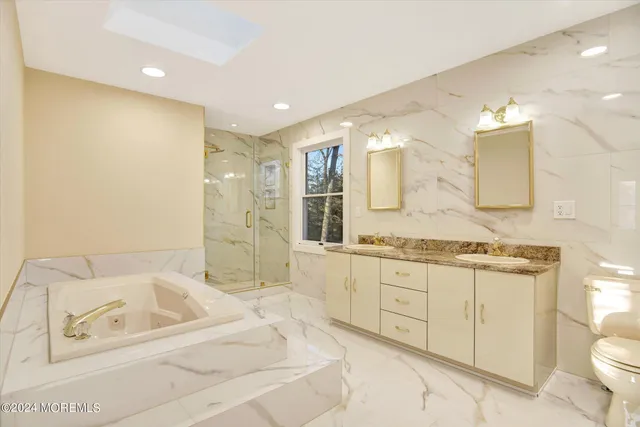 a bathroom with a granite countertop sink a toilet a mirror and shower