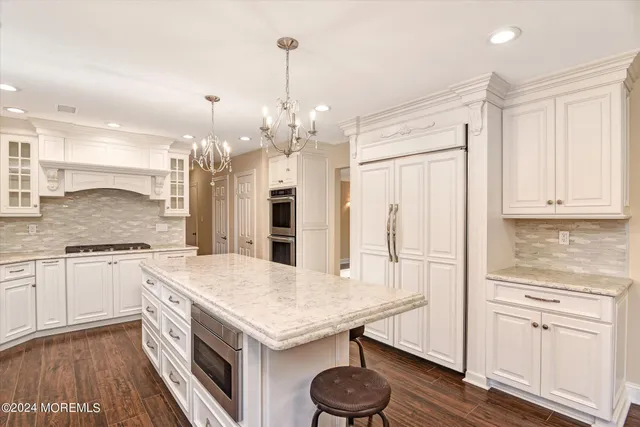 a kitchen with stainless steel appliances granite countertop a sink refrigerator and cabinets