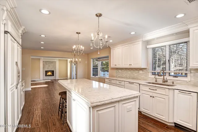 a kitchen with granite countertop a sink and dishwasher with wooden floor
