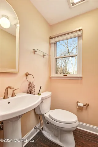 a bathroom with a sink a toilet and a mirror