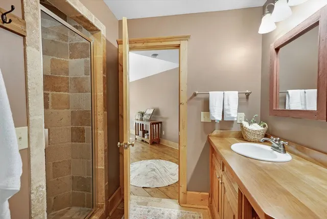 a bathroom with a sink a mirror and shower