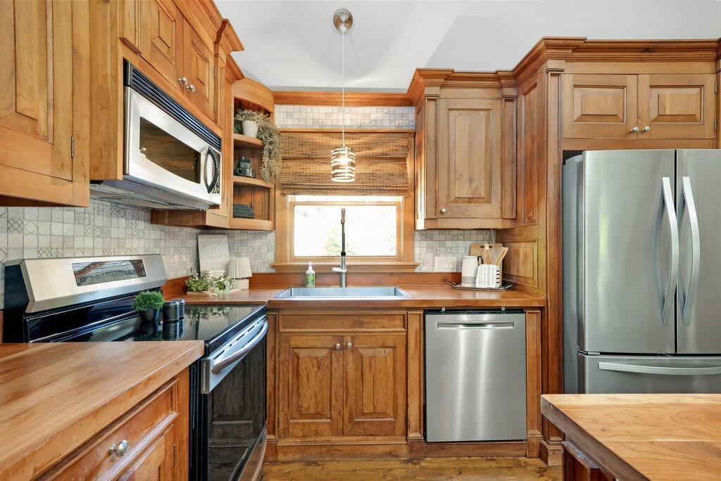 647 Omega Drive Spring City, TN 37381 - Photo 7 of 43 a kitchen with stainless steel appliances granite countertop a refrigerator a sink dishwasher a stove and white countertops with wooden floor