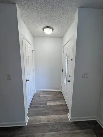 a view of a hallway with wooden floor