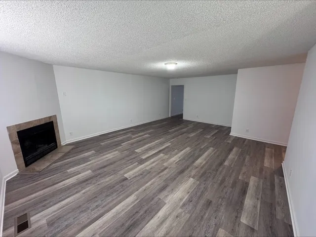 a view of a livingroom with wooden floor and a fireplace