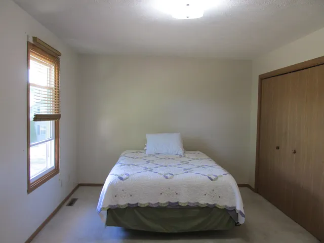 a bed sitting in a bedroom next to a window