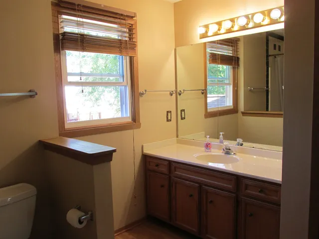a bathroom with a sink a toilet and a mirror