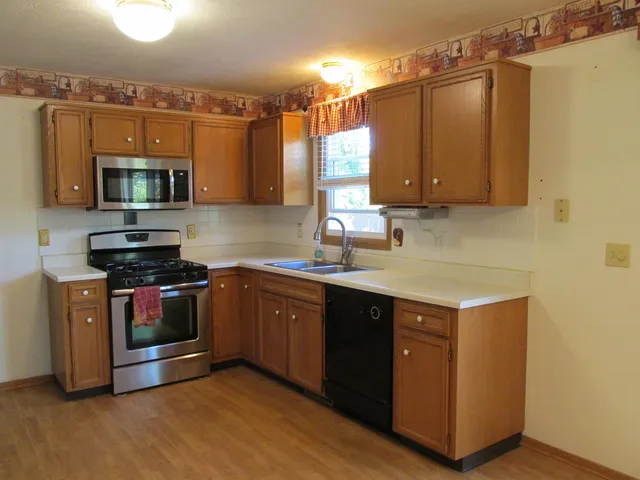 a kitchen with stainless steel appliances a stove a sink and a microwave