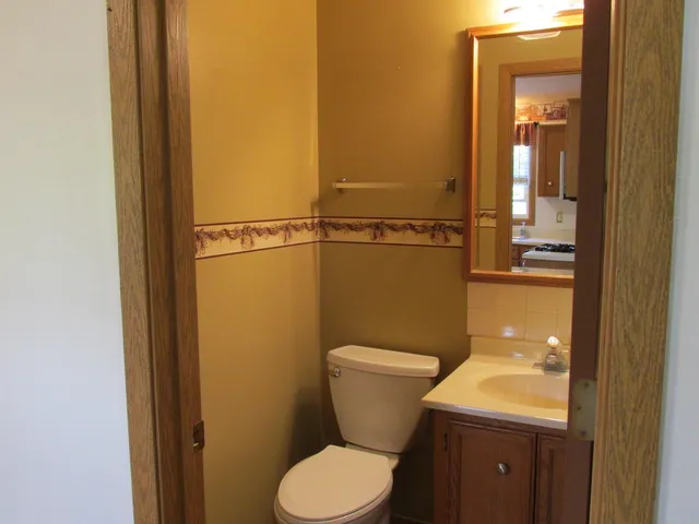 a bathroom with a toilet sink and mirror