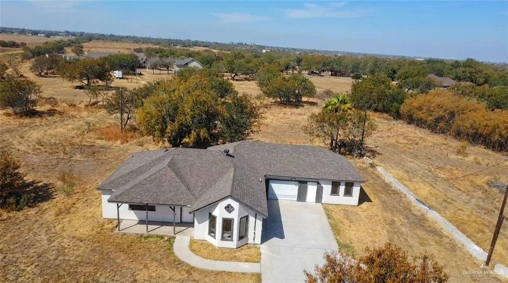 an aerial view of residential houses with outdoor space and trees