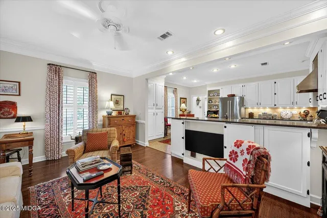 a living room with stainless steel appliances granite countertop furniture wooden floor and a large window