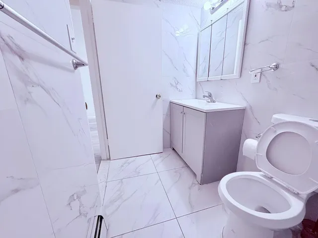 a bathroom with a sink a toilet and a mirror