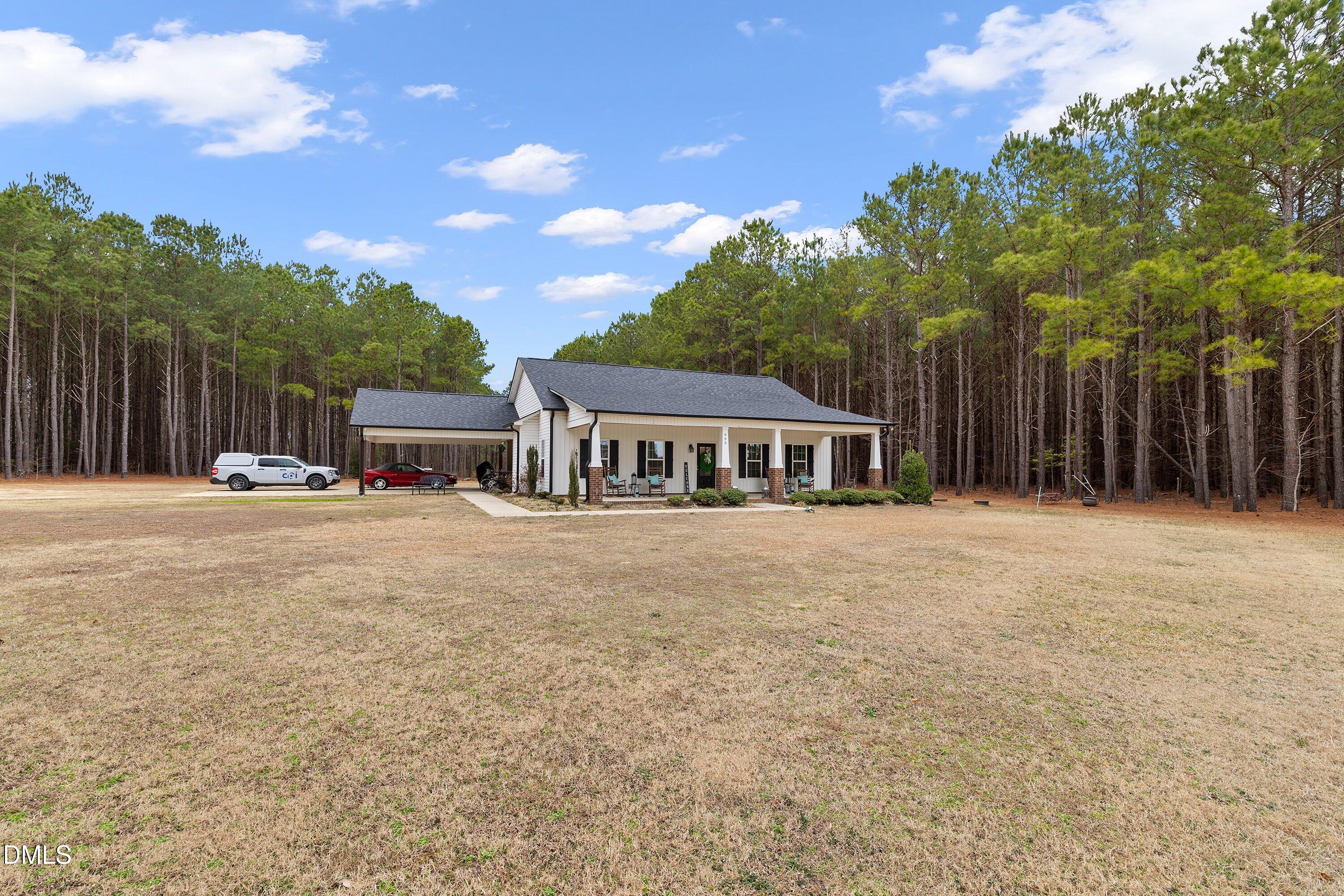 665 Mann Road Coats, NC 27521 - Photo 49 of 53 a front view of a house with a garden and trees