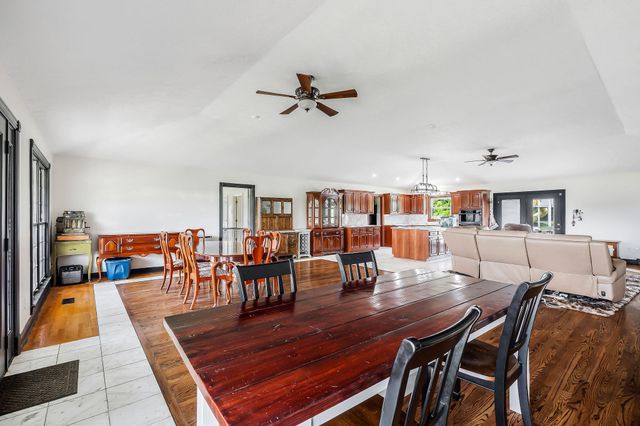 a living room with furniture and a dining table with wooden floor