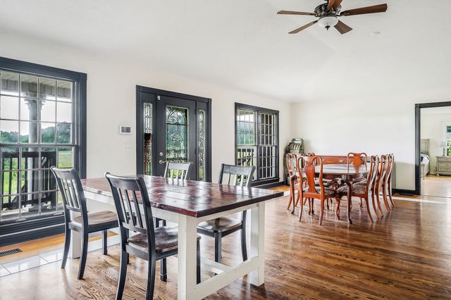 a dining room with furniture window and wooden floor