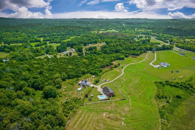 a view of a lush green forest with a houses