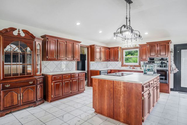 a kitchen with stainless steel appliances granite countertop a stove top oven a refrigerator a sink and dishwasher