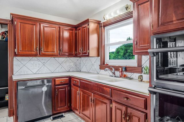 a kitchen with stainless steel appliances granite countertop a sink a stove and cabinets