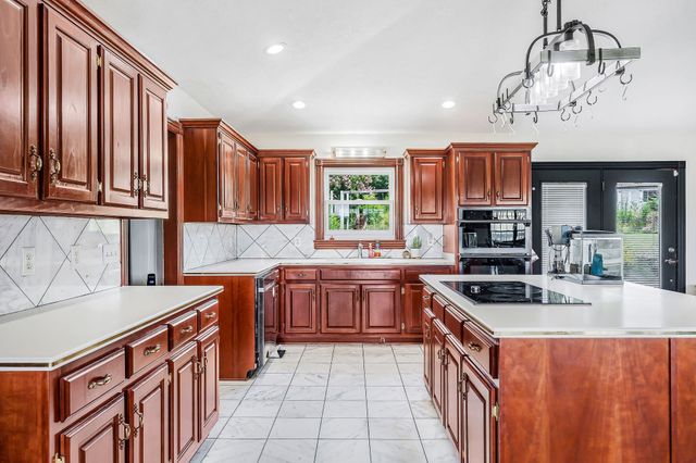 a kitchen with stainless steel appliances a sink stove and cabinets