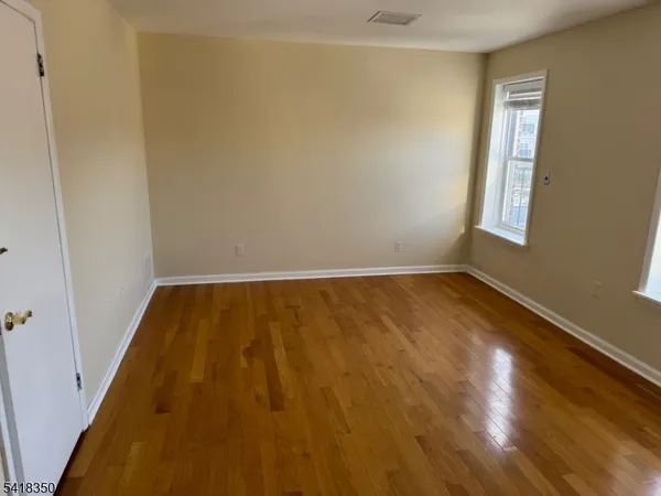 a view of room with window and wooden floor