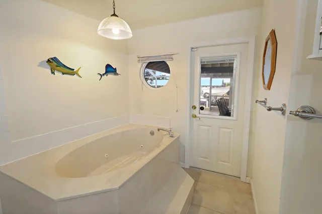 a white bath tub sitting next to a shower