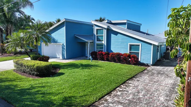 a view of a house with a yard and potted plants