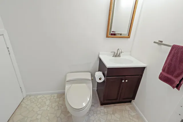 a bathroom with a toilet a sink and mirror