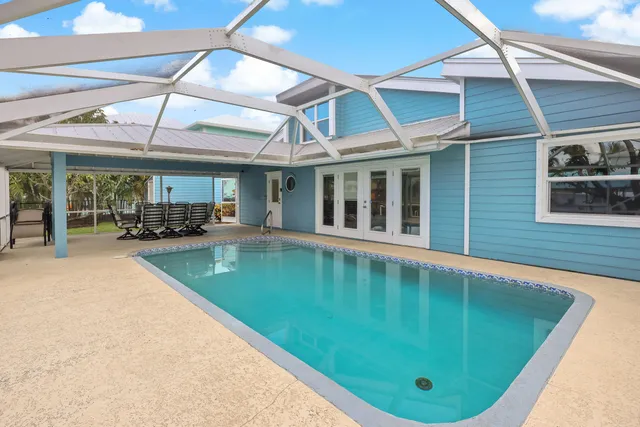 a view of a swimming pool with a patio and a yard