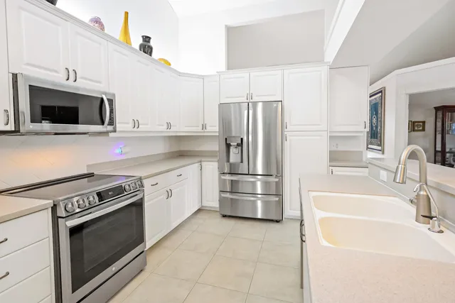 a kitchen with stainless steel appliances a refrigerator sink and microwave