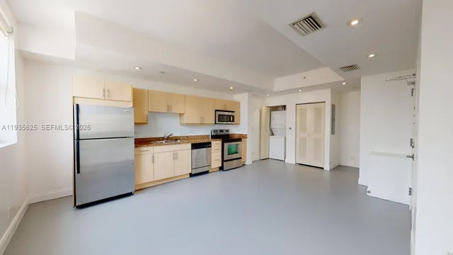 a kitchen with stainless steel appliances white cabinets and a refrigerator