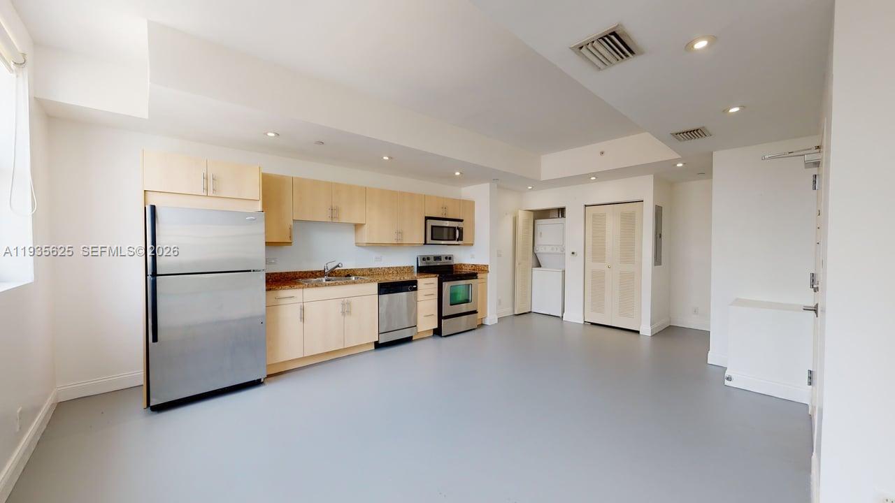 111 East Flagler Street, Unit 810 Miami, FL 33131 - Photo 3 of 19 a kitchen with stainless steel appliances white cabinets and a refrigerator