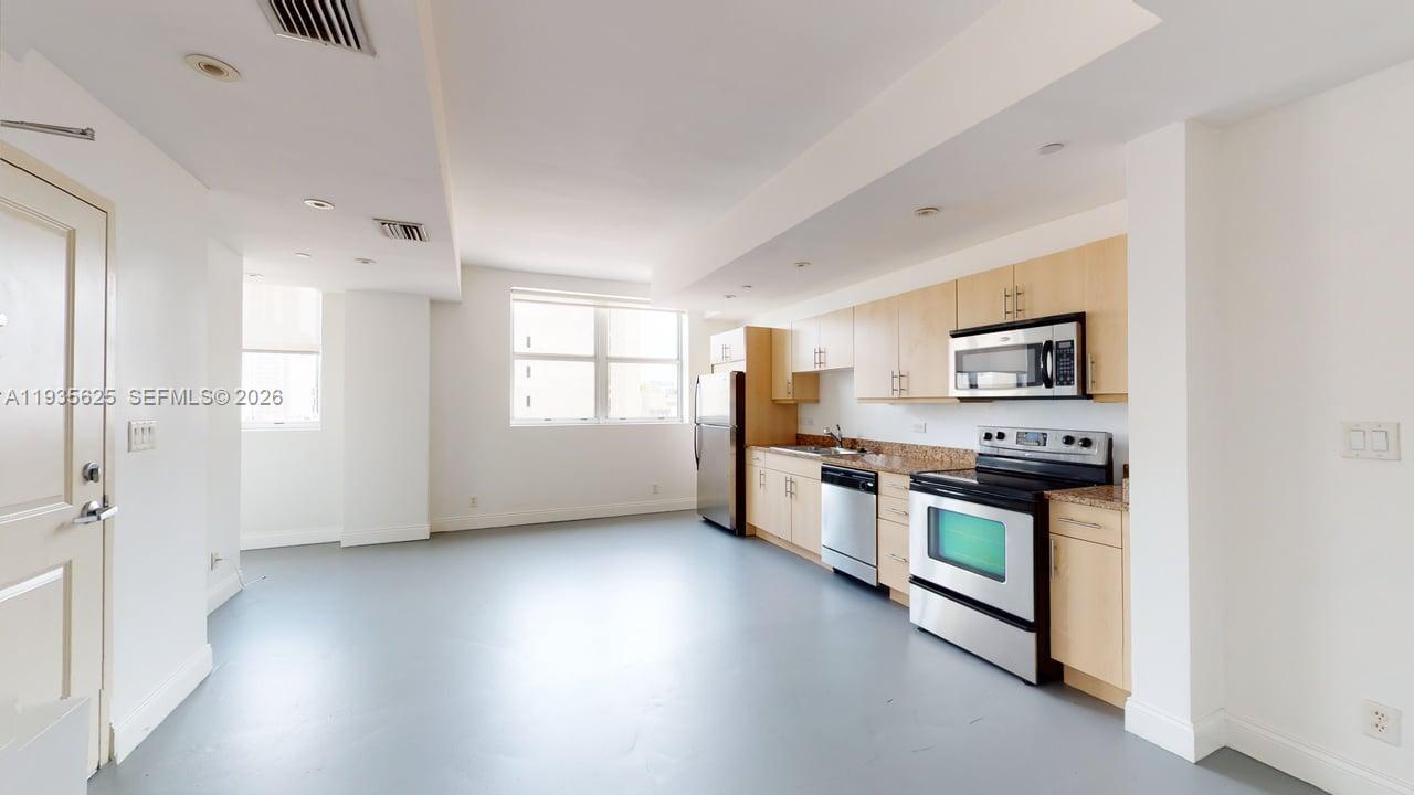111 East Flagler Street, Unit 810 Miami, FL 33131 - Photo 4 of 19 a kitchen with stainless steel appliances granite countertop a stove a sink and a refrigerator