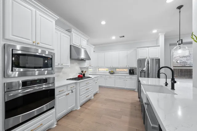 a kitchen with stainless steel appliances a stove sink and cabinets