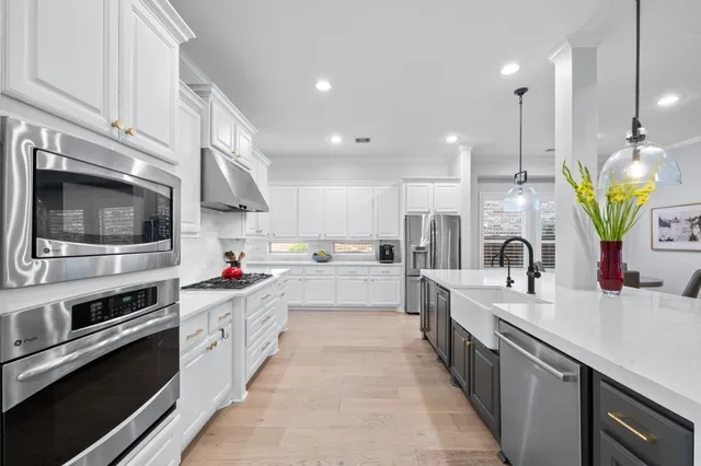 a kitchen with stainless steel appliances a sink a stove top oven a counter space and cabinets