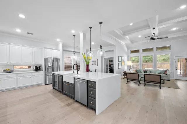 a large white kitchen with lots of counter space and stainless steel appliances