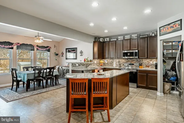 a kitchen with kitchen island a dining table and chairs