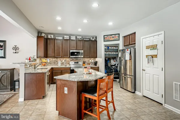 a kitchen with kitchen island a appliances dining table and chairs