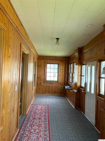 a view of a hallway with wooden floor and furniture